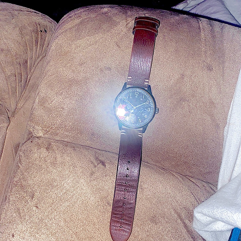 It is a black with leather watch and  on the back is stainless steel